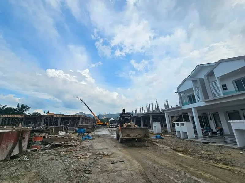 Exterior features: construction site, heavy machinery, unfinished buildings, dirt road, scaffolding, cloudy sky, surrounding greenery; style: modern.