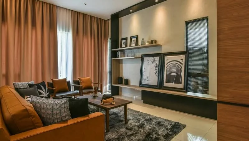Living features: brown leather sofa, two accent chairs, coffee table, area rug with shaggy texture, wall-mounted shelf, framed artwork, decorative vases, curtains in light brown, recessed downlights, wall with textured finish, large windows with blinds; style: modern.