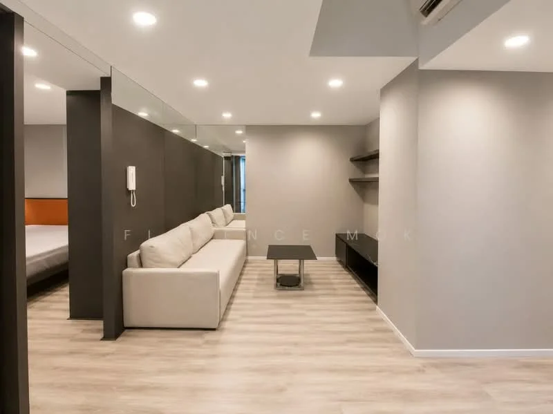 Living features: light wood laminate flooring, grey painted walls, sofa in cream fabric, coffee table with metal legs, wall-mounted TV console, built-in shelving unit, recessed LED downlights, telephone on wall, large mirror reflecting light, air conditioning unit; style: modern.