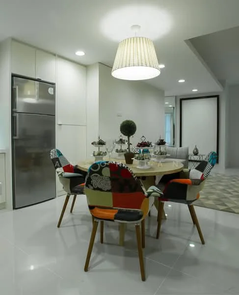 Dining features: round dining table, 6-seater dining table, upholstered dining chairs with colorful fabric, refrigerator, white cabinetry, pendant light fixture, polished tile flooring, decorative plants on the table, wall with neutral color, open layout to living area; style: modern.