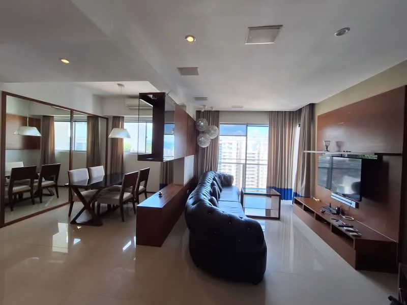 Living features: L-shape sectional sofa in dark blue, coffee table, wall-mounted TV, TV console, floor-to-ceiling windows, curtains, recessed downlights, decorative pendant lights, cream tiled flooring, wood paneling, open layout to dining area, mirrored wall feature; style: modern; view: city. Dining features: 4-seater dining table, white upholstered dining chairs, wooden dining table, decorative centerpiece; style: modern; view: city.