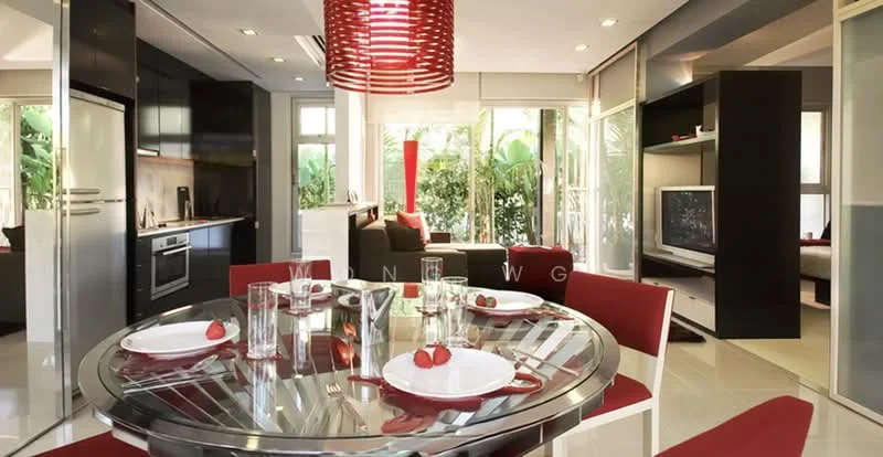 Dining features: round dining table, glass tabletop, red upholstered dining chairs, decorative centerpiece with strawberries, floor-to-ceiling windows, natural light, open layout, modern pendant light fixture, white walls, ceramic tile flooring; style: modern; view: garden. Living features: sofa, coffee table, TV console, wall-mounted TV, open shelving, greenery visible through windows; style: modern; view: garden. Kitchen features: built-in oven, stainless-steel fridge, wood cabinetry, countertop, kitchen island, open shelving; style: modern; view: garden.