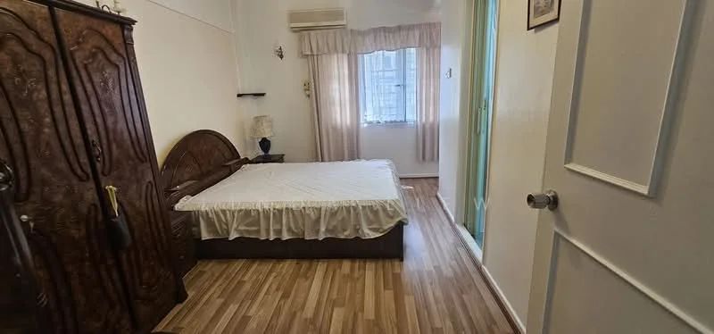 Bedroom features: queen-size bed with white bedspread, wooden wardrobe with ornate design, laminate flooring, wall-mounted air conditioning unit, curtains on window, table lamp on bedside table, door leading to another room, light-colored walls; style: traditional.