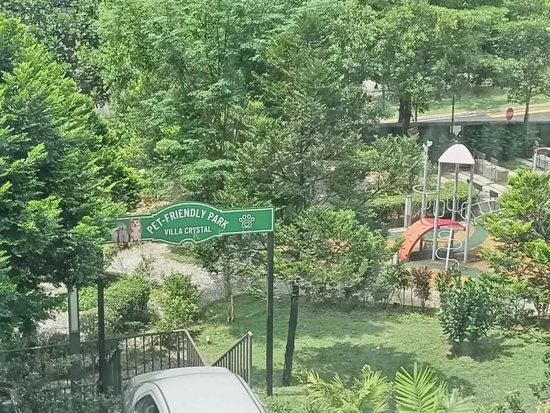 Exterior type: landscape garden; features: pet-friendly park, playground equipment, manicured lawn, mature trees, walking paths, landscaped garden, greenery, signage for park; style: modern.