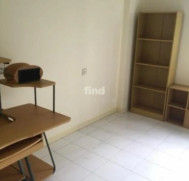 Room features: white painted walls, tile flooring, wooden shelving unit, desk with metal legs, open shelving, single electrical outlet.