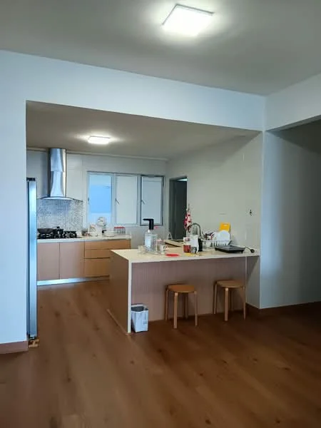 Kitchen features: light wood cabinetry, white quartz countertop, stainless-steel sink, chrome pull-down faucet, built-in gas stove, stainless-steel range hood, wall-mounted oven, white tiled backsplash, refrigerator, bar stools, open layout, laminate flooring, recessed ceiling lights; style: modern.