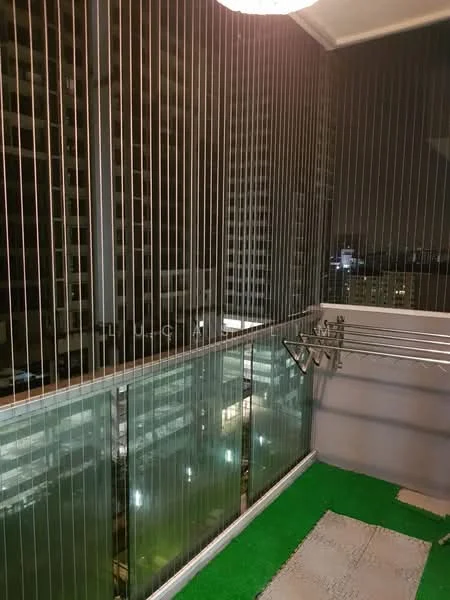 Balcony features: glass railing, artificial grass flooring, clothes drying rack, city skyline view, night lighting, concrete wall, overhead light fixture; style: modern; view: city.