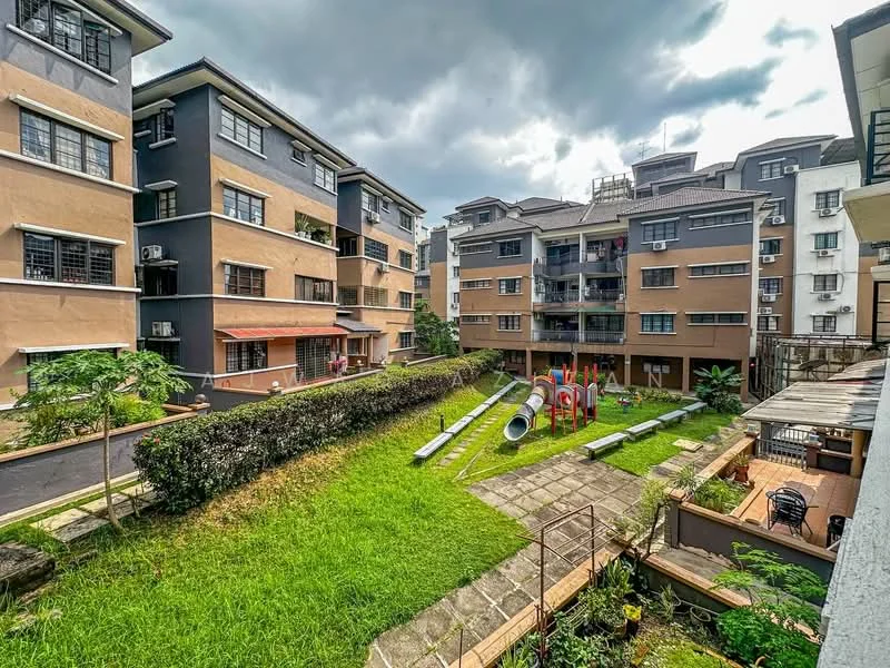 Exterior type: low-rise apartment block; features: manicured lawn, playground with slides and climbing structures, landscaped garden, multiple low-rise buildings, balconies on upper floors, parking area visible, pathway with stone paving, green shrubs, outdoor seating area, air conditioning units on walls; style: modern.