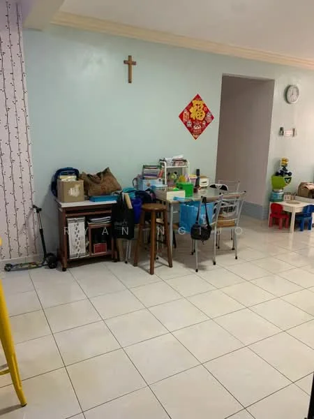 Room features: light blue painted walls, white tiled flooring, wooden table, metal chairs, various boxes and storage containers, wall clock, cross on the wall, decorative red wall hanging, plastic children's chairs, open space layout; style: modern.