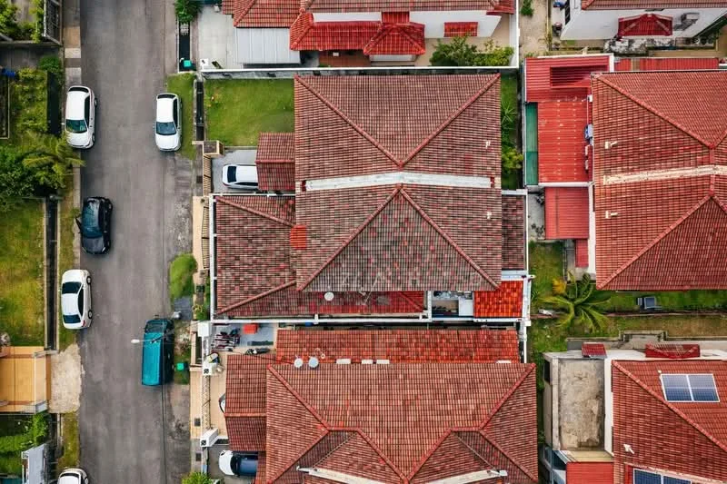 Exterior type: linked terrace house; features: red tiled roof, two-storey buildings, manicured lawns, paved driveway, surrounded by greenery, adjacent to residential street; style: modern.