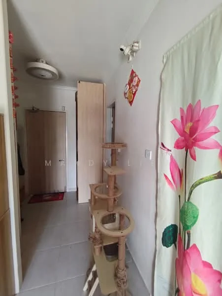 Room features: white painted walls, tile flooring, ceiling light fixture, wooden door, cat tree, decorative wall art, curtain with floral pattern.