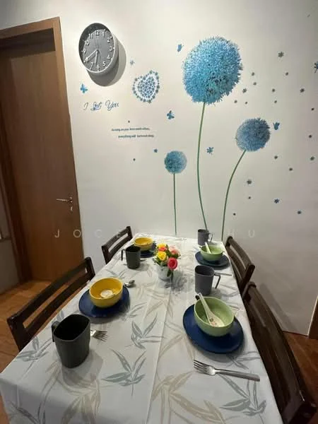 Dining features: dining table with tablecloth, 4 wooden dining chairs, blue round plate, green bowl, yellow bowl, cutlery including forks and spoons, decorative flower centerpiece, wall clock, wall with floral decals, painted wall with quote, wooden door, laminate flooring; style: modern.