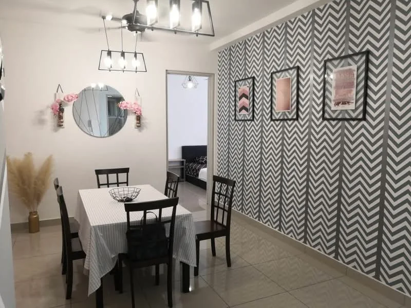 Dining features: dining table with white tablecloth, 6 dining chairs with black frames, chevron patterned accent wall in grey and white, round mirror on wall, decorative wall art in frames, wall-mounted planters with pink flowers, ceramic vase with dried plants, polished tile flooring, ceiling light fixture with multiple bulbs; style: modern.