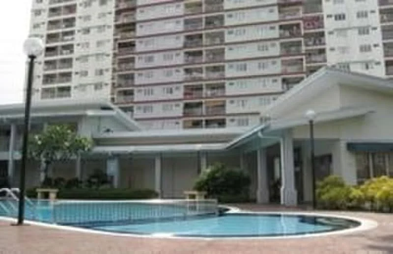 Exterior type: high-rise condominium; features: swimming pool, pool deck with loungers, landscaped garden, covered pavilion, multiple storeys, balconies on upper floors, lampposts around the pool area; style: modern.