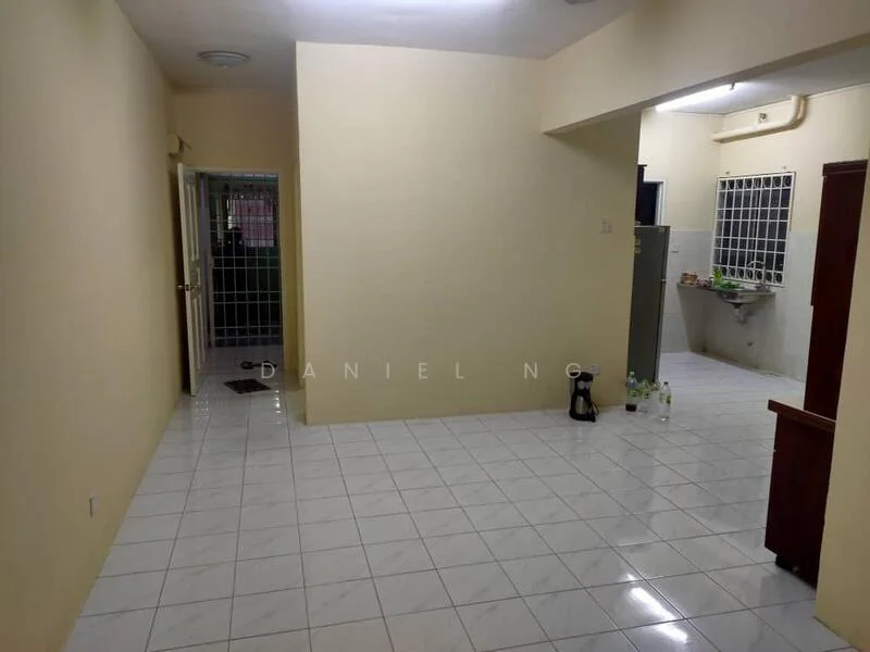 Room features: cream painted walls, white tiled flooring, ceiling light fixture, window with metal grille, kitchen area visible with sink, countertop in kitchen area, doorway leading to another room, water bottles on floor.