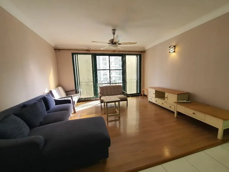 Living features: 3-seater fabric sofa in navy blue, 2-seater fabric sofa in light grey, wooden coffee table, TV console with storage, laminate flooring, ceiling fan with light, wall-mounted light fixture, floor-to-ceiling windows, curtains, neutral painted walls; style: modern.
