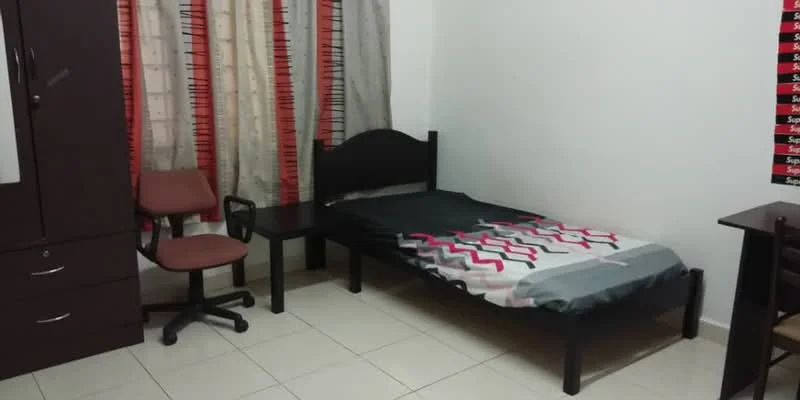 Bedroom features: single bed with black frame, grey and pink patterned bedding, wooden bedside table, office chair with wheels, dark wood wardrobe with drawers, cream painted walls, tiled flooring, curtains with a geometric pattern.