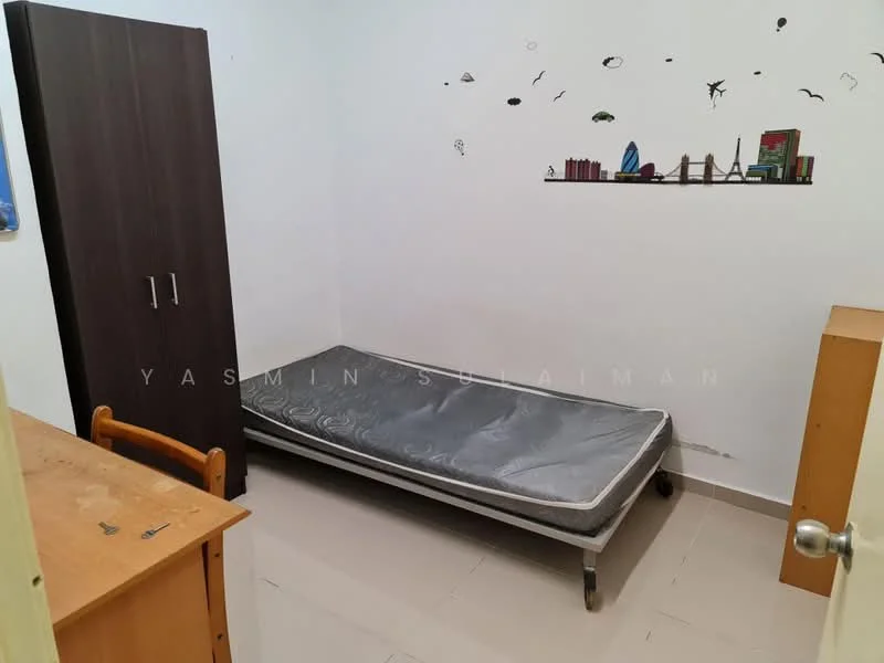 Room features: single bed frame with mattress, wooden wardrobe in dark brown, wooden desk, light-colored wooden bedside table, plain white walls, tile flooring, decorative wall stickers, window with no visible treatment; style: minimalist.