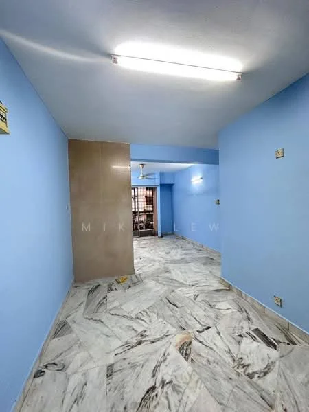 Room features: blue painted walls, marble tile flooring, fluorescent ceiling lights, ceiling fan, window with metal grille, corner wall with tile cladding, open layout, no visible furniture; style: modern.