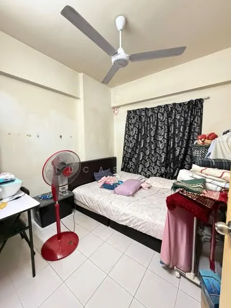 Bedroom features: single bed, upholstered headboard, bedside table, ceiling fan, blackout curtains, white painted walls, tile flooring, stack of blankets, desk with chair, standing fan.