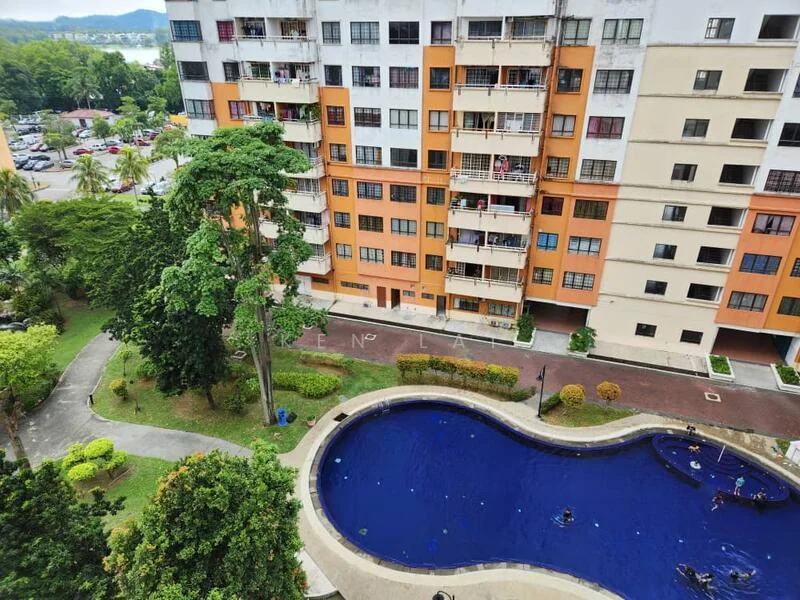 Exterior type: mid-rise condominium; features: orange and cream painted facade, balconies with railings, landscaped garden with trees, swimming pool with curved shape, pool deck with loungers, manicured lawn, paved walkway, parking area visible, surrounded by greenery; style: modern.