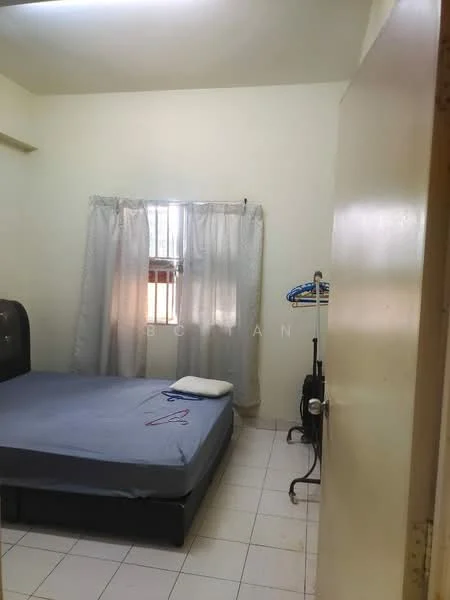 Bedroom features: single bed, grey bedspread, white walls, tile flooring, window with sheer curtains, clothes rack, hanging clothes, white ceiling, light fixture, door, small pillow.