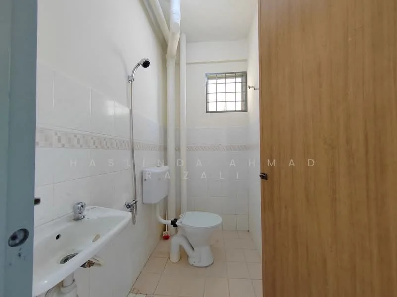 Bathroom features: white tiled walls, cream tiled flooring, single-bowl sink, chrome faucet, toilet, shower with wall-mounted showerhead, window for natural light, exposed plumbing, wooden door.