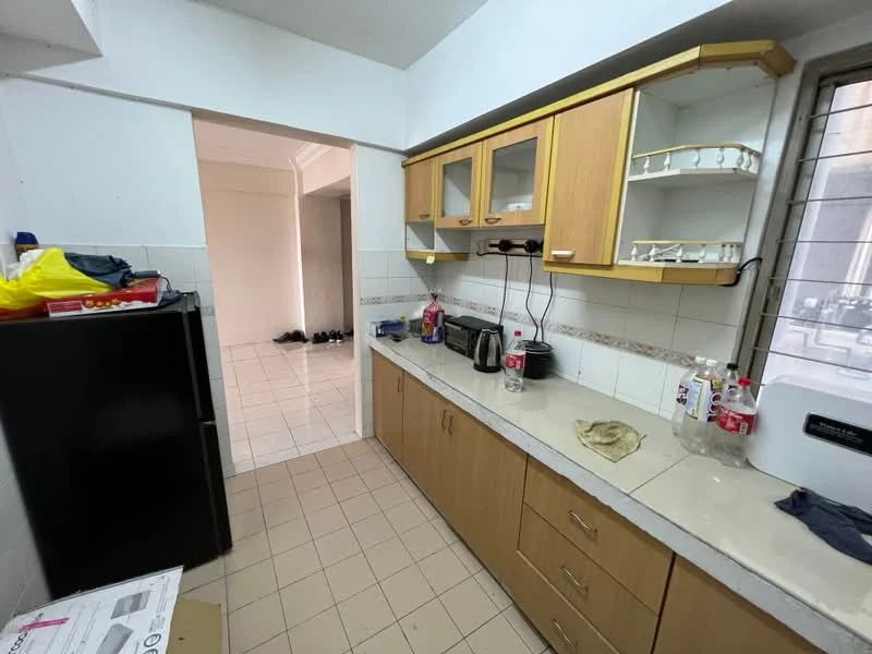 Kitchen features: brown wooden cabinetry, white countertop, stainless-steel sink, chrome faucet, black fridge, built-in microwave, toaster, kettle, tile backsplash, cream tiled flooring, window with metal grille, open shelving, countertop appliances, water bottles, cleaning cloth.