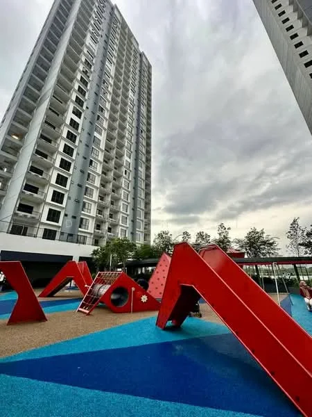 Exterior type: high-rise condominium; features: tall residential building, playground with climbing structures, colorful play equipment, rubberized flooring in blue, landscaped area with trees, cloudy sky, modern architectural design; style: modern.