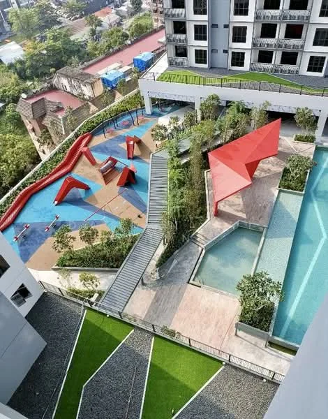Exterior type: high-rise condominium; features: children's playground with climbing structures, landscape garden with manicured grass, swimming pool with deck area, red geometric pavilion, stone-paved walkway, tropical landscaping with plants, multi-level outdoor space, water feature in pool area; style: modern.