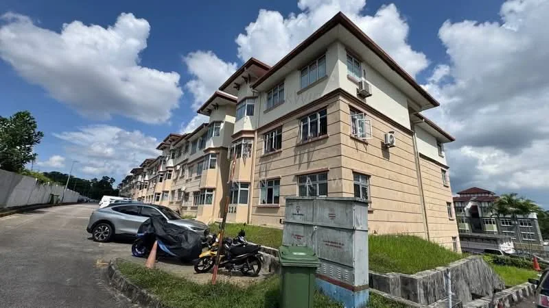 Exterior type: low-rise apartment block; features: cream painted facade, exposed concrete, 2-storey building, multiple air conditioning units, landscaped grass area, parking area, surrounding trees, driveway, covered parking, visible motorcycle parking; style: modern.