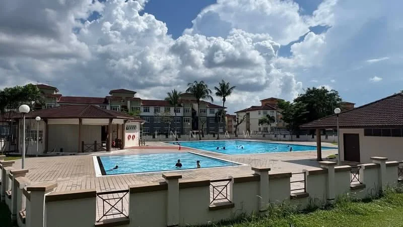 Exterior type: swimming pool deck; features: two swimming pools, surrounding paved deck, landscaped grass area, palm trees, residential buildings in background, covered pavilion, poolside lighting, fenced perimeter; style: modern.