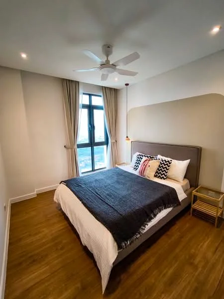 Bedroom features: king-size bed, upholstered headboard, white bedding, decorative throw pillows, wooden bedside table, pendant light fixture, 5-blade ceiling fan, floor-to-ceiling window, curtains, wooden flooring, accent wall with paint design; style: modern; view: city.