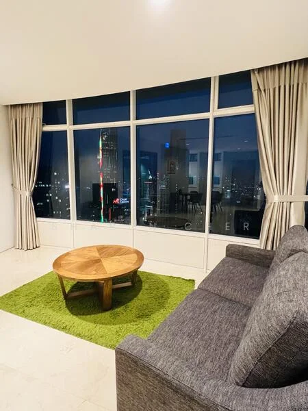 Living features: floor-to-ceiling windows, grey fabric sofa, round wooden coffee table, green area rug, curtains, city skyline view, marble flooring, decorative wall art; style: modern; view: city.