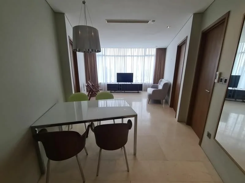 Dining features: glass dining table, 4 dining chairs in brown and green, marble flooring, recessed ceiling lights, large windows with sheer curtains, wall-mounted TV, sofa in light grey, wooden sideboard, decorative mirror on wall; style: modern; view: city.