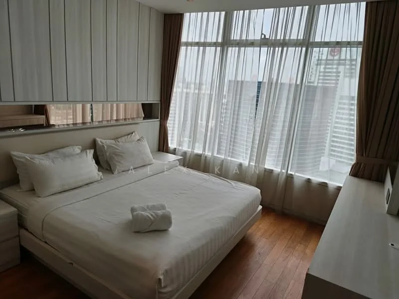 Bedroom features: king-size bed, upholstered headboard, white bedding, wooden flooring, floor-to-ceiling windows, sheer curtains, city view, nightstand, table lamp, built-in wardrobe, wall-mounted TV, decorative wall paneling; style: modern; view: city.