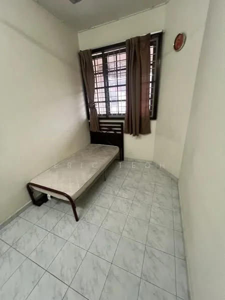 Bedroom features: single bed frame, white walls, tiled flooring, window with metal grille, brown curtains, wall clock, corner placement, natural light from window.