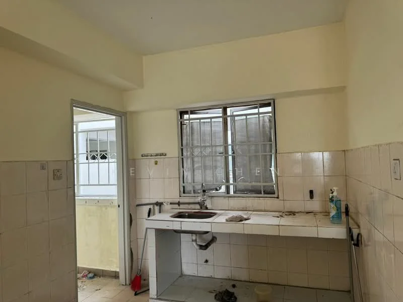Kitchen features: white painted walls, cream tiled backsplash, white tiled flooring, single-bowl stainless-steel sink, wall-mounted faucet, window with metal grille, countertop with storage cabinets below, cleaning supplies visible.