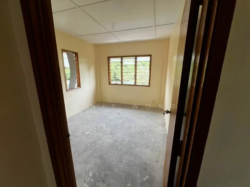 Room features: light beige painted walls, concrete flooring, three wooden windows with grilles, plain ceiling, no visible furniture, empty room; view: garden.