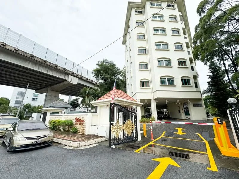 Exterior type: low-rise apartment block; features: white painted facade, 5-storey building, main entrance gate with decorative design, security boom gate, paved driveway, surrounded by greenery, adjacent to elevated train track; style: modern.
