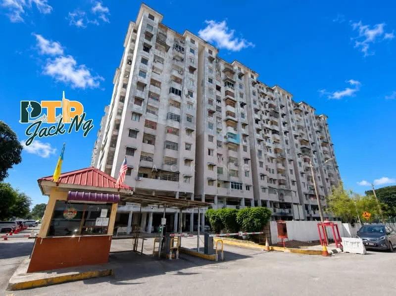 Exterior type: mid-rise condominium; features: white painted facade, balconies on multiple floors, security guard house at entrance, gated entry, surrounded by greenery, parking area, clear blue sky, flagpole with Malaysian flag; style: modern.