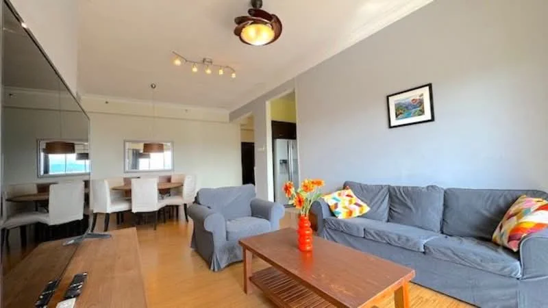 Living features: grey fabric sofa, 2-seater grey fabric sofa, coffee table, wooden coffee table, pendant light fixture, recessed ceiling lights, decorative wall art, wooden flooring, decorative throw pillows, mirror on wall, dining area visible in background, dining table with white upholstered chairs; style: modern.