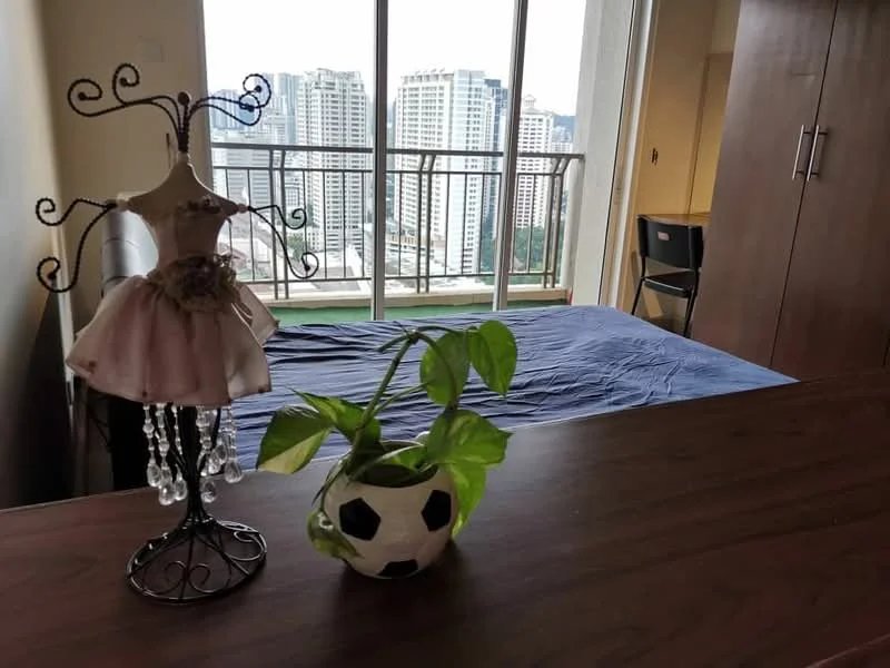 Bedroom features: queen-size bed with blue bedding, decorative dress form, potted plant in soccer ball planter, floor-to-ceiling windows, curtains, wooden wardrobe, chair, wooden table; style: modern; view: city.