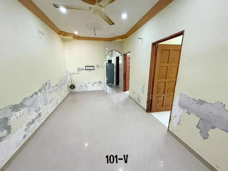 Room features: cream painted walls with peeling paint, polished ceramic tile flooring, ceiling fan, wooden door, arched doorway, light fixture on ceiling, baseboards, wall-mounted electrical outlet.