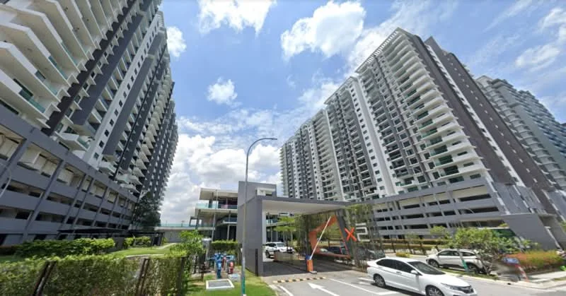 Exterior type: high-rise condominium; features: glass curtain wall, white painted facade, balconies on upper floors, landscaped garden area, driveway with marked parking, multiple storeys, surrounded by greenery, main entrance with awning; style: modern.