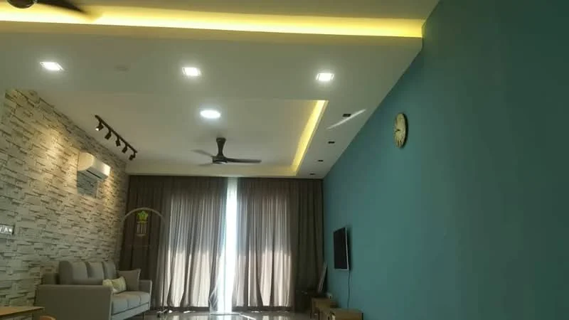 Living features: grey fabric 3-seater sofa, wall-mounted TV, wooden TV console, stone accent wall, blue painted walls, recessed LED downlights, ceiling fan with light, floor-to-ceiling windows with sheer curtains, marble flooring, decorative wall clock; style: modern.