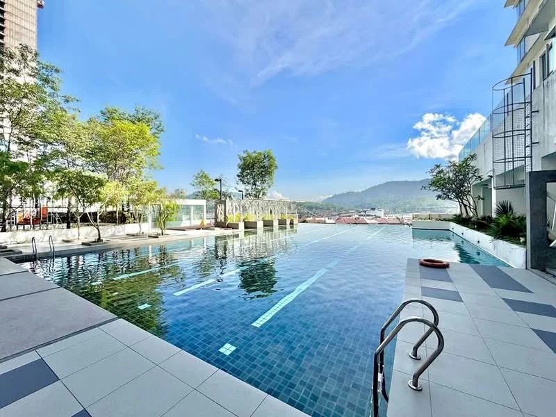 Exterior type: swimming pool deck; features: infinity pool, pool deck with loungers, surrounded by greenery, mountain view in background, tiled flooring, landscaped garden area, safety railing, poolside lighting; style: modern.