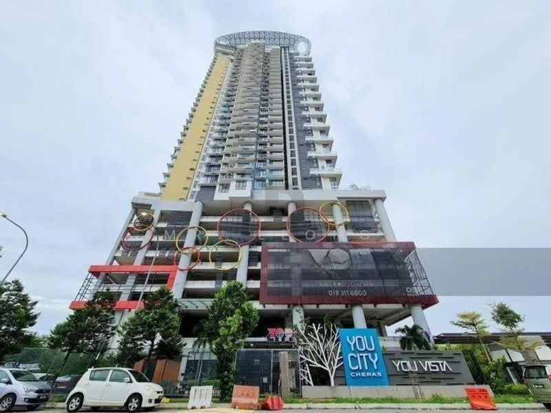 Exterior type: high-rise condominium; features: glass curtain wall, projecting balconies, feature lighting, multi-storey structure, manicured landscaping, signage at ground level, parking area visible, surrounded by greenery; style: modern.