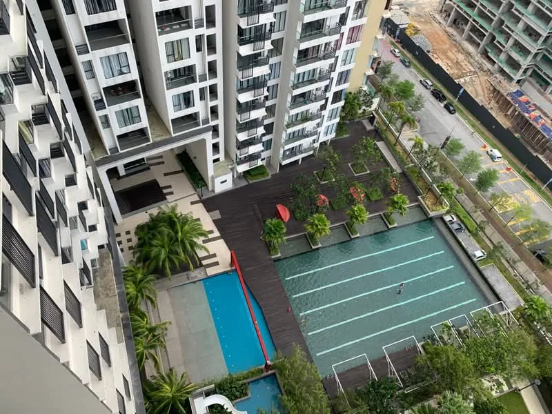 Exterior type: high-rise condominium; features: infinity pool, lap pool, pool deck with loungers, landscaped garden, manicured lawn, palm trees, red umbrellas, wooden decking, surrounding construction site, urban context with road view; style: modern.