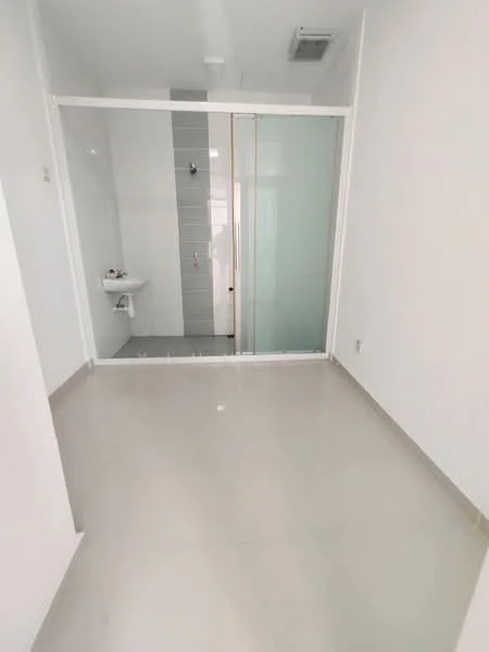 Bathroom features: white painted walls, light grey tiled wall, glass shower enclosure, white sink, toilet, neutral tile flooring, recessed ceiling lights, sliding glass door; style: modern.
